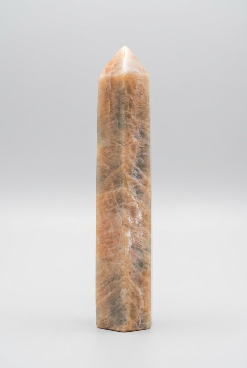 Perzik maansteen punt van 436 gram en 18 cm met warme perziktinten, crèmekleurige zones en grijze natuurlijke tekeningen.