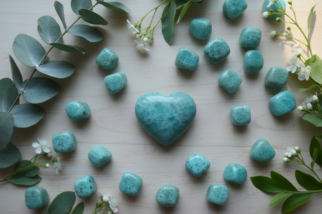 Turquoise amazoniet stenen en hart op houten ondergrond met eucalyptustakjes, witte bloemen en groene bladeren in zacht koel licht