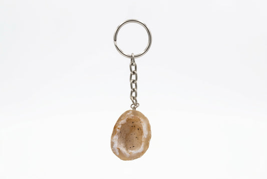 Beige agaat sleutelhanger met een lichte rand en donkere spikkeltjes, met zilverkleurige ketting en sleutelring