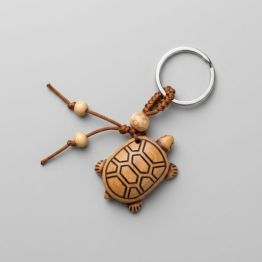 Houten schildpad sleutelhanger met beige schild en bruine lijnen, geknoopt koord, houten kraaltjes en zilverkleurige sleutelring