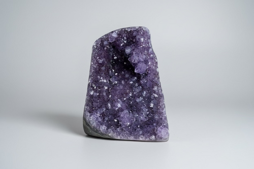 Amethist geode cut base Š paarse kristallen binnenkant op natuurlijke ondergrond