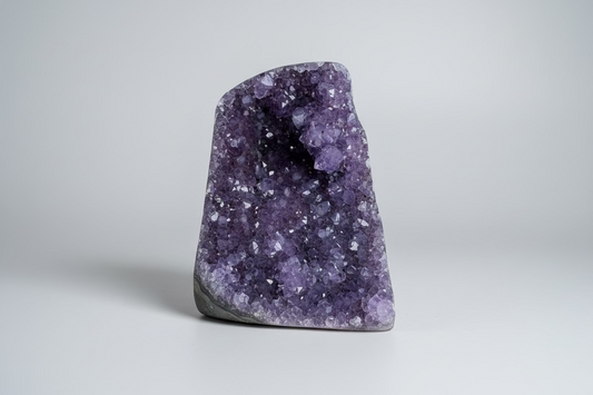 Amethist geode cut base Š paarse kristallen binnenkant op natuurlijke ondergrond