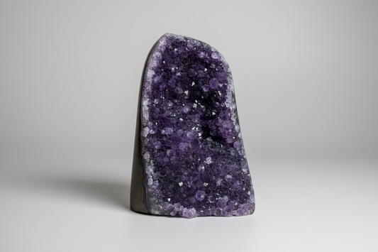 Amethist geode cut base Š paarse kristallen binnenkant op natuurlijke ondergrond