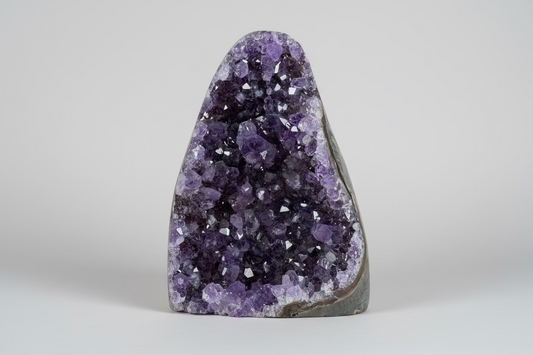 Amethist geode cut base Š paarse kristallen binnenkant op natuurlijke ondergrond