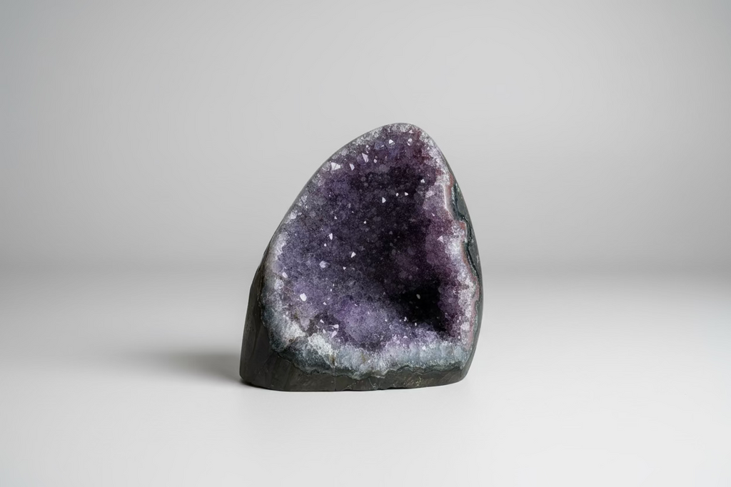 Amethist geode cut base Š paarse kristallen binnenkant op natuurlijke ondergrond