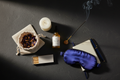 Blauwe Lotus Ritual Kit met tinctuur, thee, oogmasker, kaars, wierook en journal op donkere natuursteen ondergrond